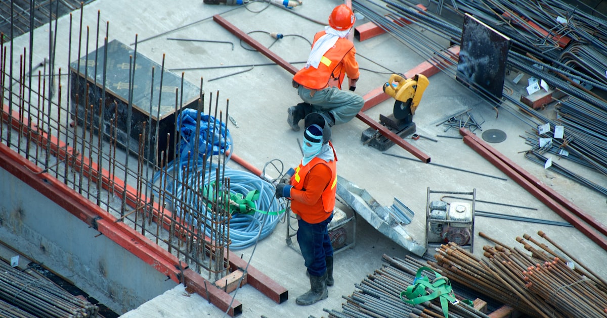 Construction site in tropical climate with scaffolding and workers